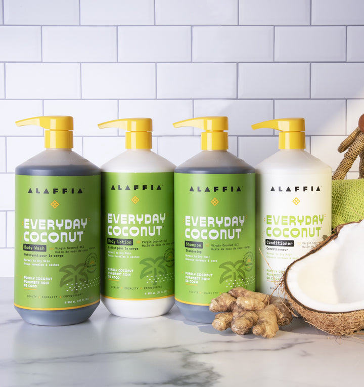 fair trade coconut conditioner, shampoo, lotion, and body wash pictured with coconut and ginger